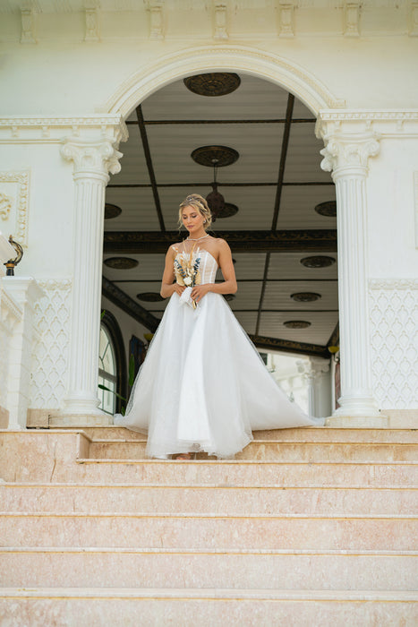 Modern bridal gown with corset and long train.