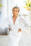 Features a deep plunging neckline that delicately connects with raised waistline seam, complemented with sheer chiffon long sleeves, mermaid cut with modern open back, long train wedding dress.