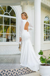 Features a deep plunging neckline that delicately connects with raised waistline seam, complemented with sheer chiffon long sleeves, mermaid cut with modern open back, long train wedding dress.